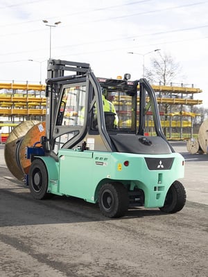 Hinteransicht eines Mitsubishi-Gabelstaplers mit Fahrer im Außeneinsatz.